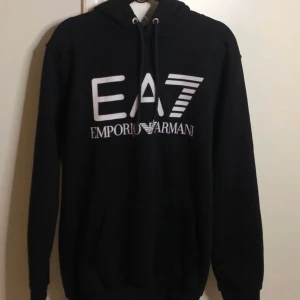 emporio armani hoodie i svart/grå - En svart emporio armani hoodie i svart färg nyskick storlek Medium finns även en likadan i grå