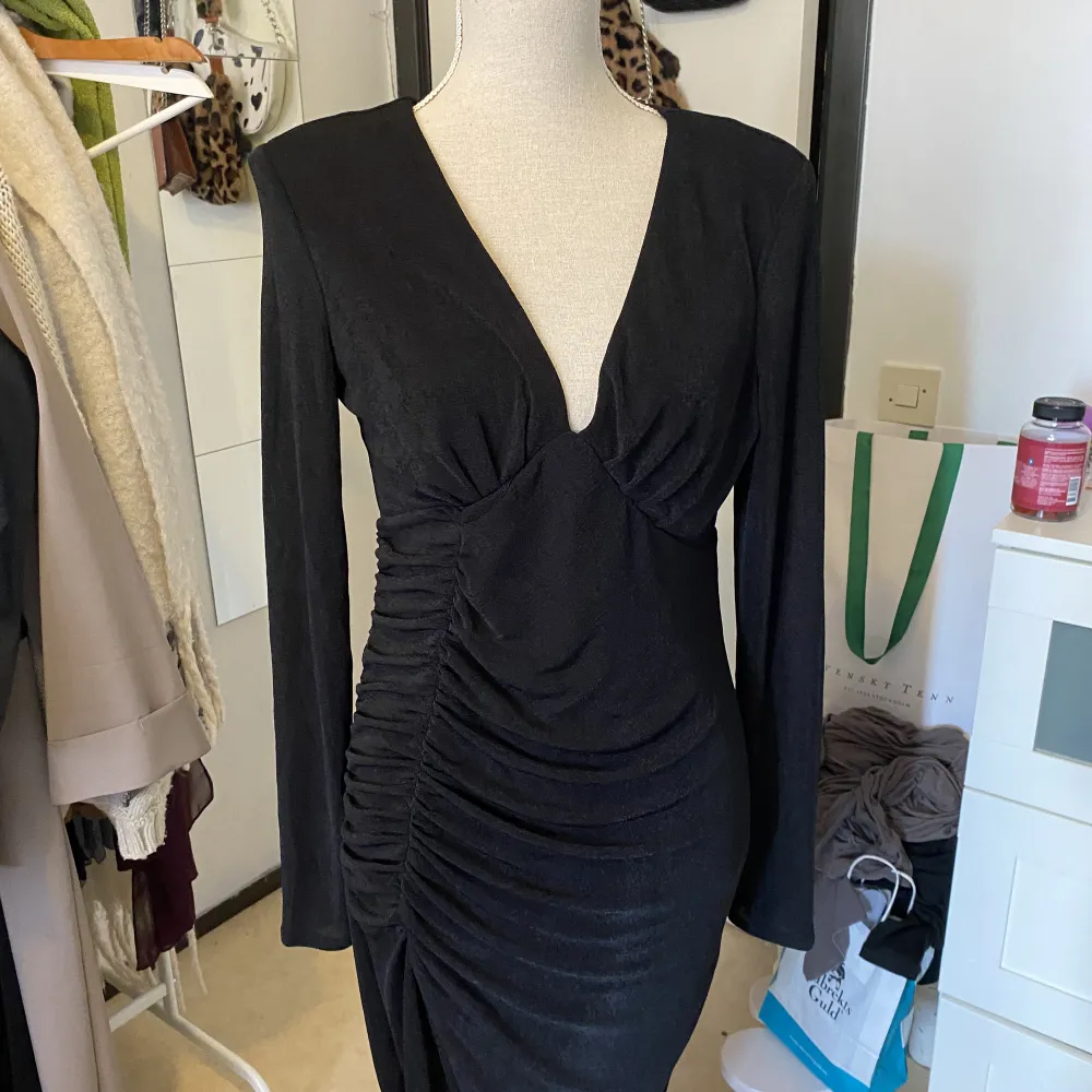 Glittrig svart fest/aftonklänning med snygg rouching på sidan och slit. Aldrig använd och i helt nytt skick. Klänningar.