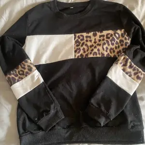 En svart sweatshirt men vit och leopard mönster på. Använder inte längre 💗
