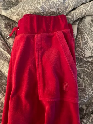 Röda Juicy Byxor  - Säljer mina röda juicy byxor då dom inte används. Dom är en del använda sen innan men dom är i väldigt bra skick, inget sönder eller något sånt. Byxorna ser lite rosa ut i dagsljus. Kan tänka mig sälja dom för lite mindre så kom med prisförslag isåfall! 