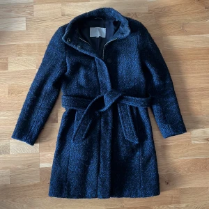 Snygg jacka - Väldigt fin kappa från MQ (InWear), den är mörkblå/svart och färgen syns bäst på bilden när den är fotograferad på golvet, bra skick, väldigt varm och skön, dragkedja, strl 34. Nypris 700kr.