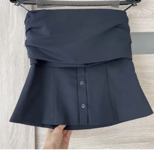 Tubtopp - Tubtopp i skjortliknande material. Första bilden är inte min och andra från hemsidan, skriv om ni vill ha fler egna bilder. Den är i mörkblå färg. 