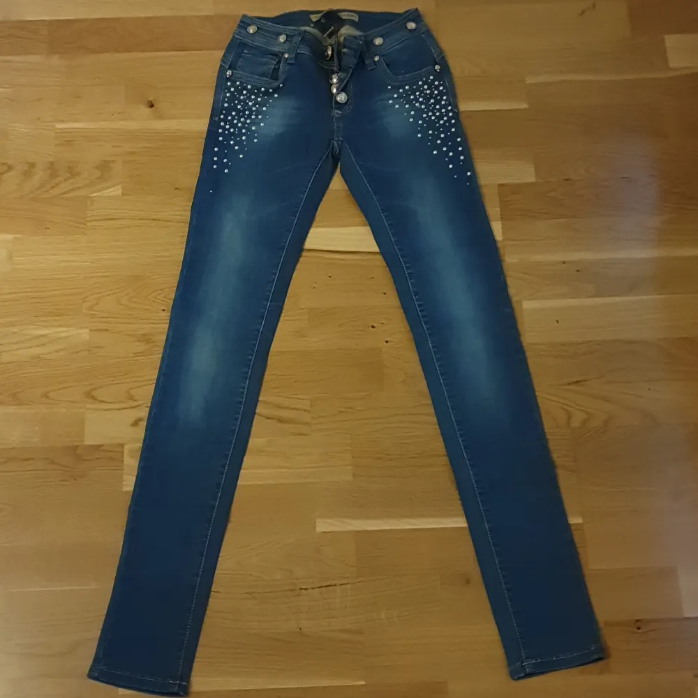 Oanvända jeans, står att det är storlek S men skulle nog passa någon med XS också eftersom den verkar vara liten i storleken 😊 jättefina rhinestones, jag skickar gärna fler bilder . Jeans & Byxor.