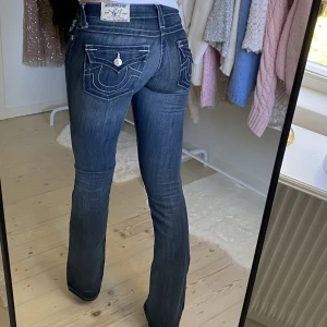 True religion jeans - Lågmidjade bootcut jeans från True Religion. Det är i mycket bra skick, ser nya ut förutom fläcken längst ner på ena benet, se bild tre, vet ej om det går att tvätta bort. Midjans höjd - 16cm. Midjans bredd 37cm, Innerbensmåttet 87cm. Jag är 179cm lång🩷