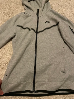 Nike tech  - Hej säljer denna då jag inte gillar längre den typ av stil, allting e bra på den det är ba kedjan som man kan se på bilderna och gått i sönder lite pågrund av tvätt maskinen, det är en storlek S. men annars är den hur bra som helst inget fel alls med den.