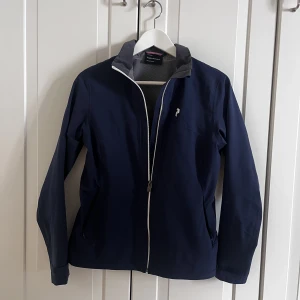 Vindjacka - Snygg vindjacka från Peak Performance golfkollektion. Väldigt sparsamt använd. Passar till golfrundan, promenaden, löprundan mm