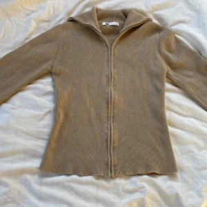 Flash kofta/zip-up - Kofta/zip-up från märket Flash. Storlek S. Har ganska tjockt material men sätter sig fint runt kurvorna och midjan. Har används fåtal gånger. Halsen kan man justera själv som man vill ha den. Om du har frågor skriv till mig.