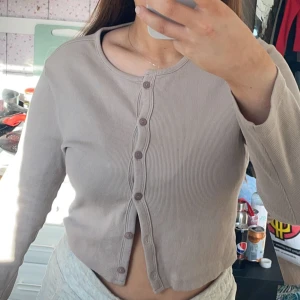 Tröja med knappar  - Bra skick, färgen på bilden är orättvis, den är beige.