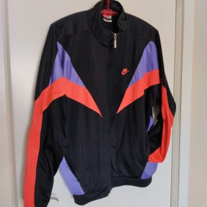 Vintage Nike Track Jacket Strl L  - Vintage Nike Track Jacket från 90-talet, One Bowerman Drive broderat på ryggen och broderad Nike logga fram. Ett måste för kyligare sommarkvällar nu när 90-talet är hetare än någonsin. Skickas mot att köparen betalar frakt, 75kr spårbart med Postnord. 