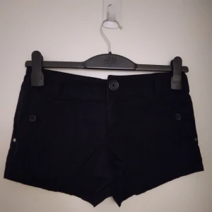 Svarta korta shorts från H&M. Strlk 34 / XS. Har flera fickor. - Svarta korta shorts från H&M. Strlk 34 / XS. Har flera fickor, alla med knapp.  Stängs med dragkedja och knapp. Materia: Lite kraftigare men lent bomullstyg. Felfria.   Säljer även vita likadana - se mina annonser.