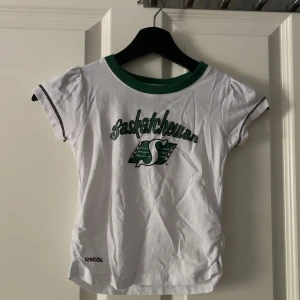 Babytee  - Supersöt babytee från Reebok. Så fin och funkar till allt. Köpt secondhand, säljer då den tyvärr inte passade mig. Bra skick. 80kr+frakt