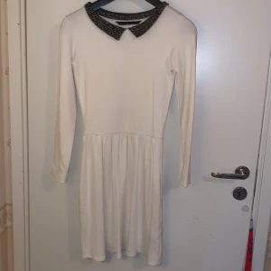Vit klänning med Leopard krage - En vit klänning med en leopard krage. Är 162 cm och den är ned till mina knän. Passar bra i storlek S och M. Har två fickor vid sidan om.