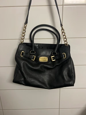 Michael kors väska  - Svart väska med gulddetaljer från Michael Kors som är sparsamt använt. Inköpt i USA.