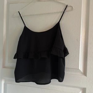 Linne - Ett svart linne med volang! Passar till iprincip allting, super härlig 