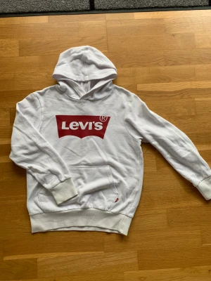 Levis hoodie barn  - Levis hoodie i storlek 140cm. Den är använd ganska mycket och är i okej skick. Lite missfärgad på dom räfflade delarna. Luvan är ganska liten. Originalpris är 599kr. 