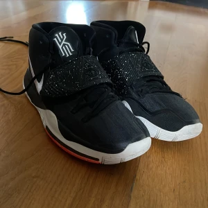Kyrie 6 Jet black  - Kyrie 6 jet black, basket skor. Har använt skorna på uteplan som ni ser på bilden, sitter lite småsten under men det är ingenting som stör inomhus, har fått bort de värsta👍, st 46