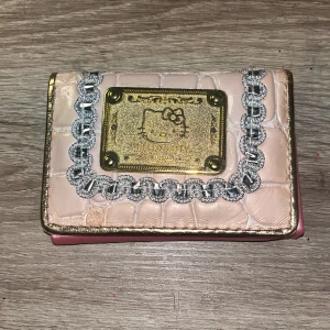 Hello kitty plånbok - Jättesöt och fin hello kitty plånbok! De har flera olika fack för sedlar/kontanter/kort. Du kan sätta in bild där hjärtat är! 