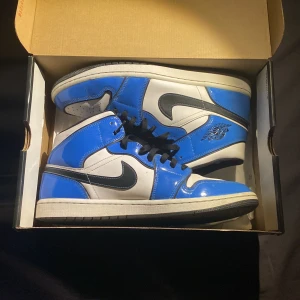 Air Jordan 1 - Det är ett par fina Air jordan 1 Mid SE Signal blue, storlek 45.5 . Som har använts ungefär 3 månader, men som bara har stått i snart 2 år. Du får även med ett par crease skydd för de priset. Hör av dig om du e intresserad. 