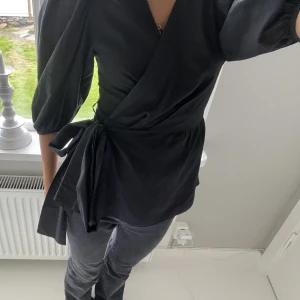 Svart omlott blus  - Super snygg svart blus med en knytning i midjan. Använd vid ett tillfälle🥰🥰