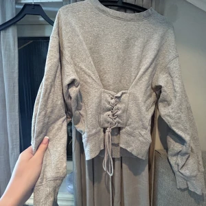 Grå tröja me snörning  - Storlek S Grå tröja  