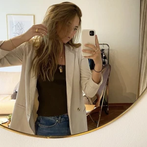 Beige kavaj - Har en skada på armen (se bild) jag använder ändå den med uppkavlade armar! 