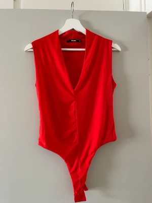 Röd body - Röd body med en liten krage som är helt oanvänd