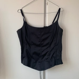 Svart satin korsett - Svart vintage korsett i satin från Hennes, den har vacker hög kvalitet snörning i ryggen 