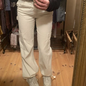 Vita cargo byxor - Vita cargo byxor från hm i storlek 36. Sytt om dom nertill och lagt in snören för att kunna dra åt. Väldigt snygga men inte min stil längre. 