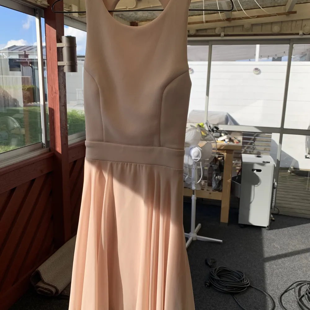 Fin sommar klänning i storlek S. Klänningen är ljusrosa och är korsad i ryggen. . Klänningar.