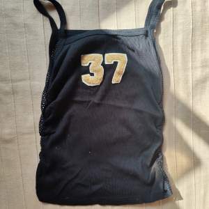 Sportigt svart linne från tidigt 2000-tal, hålstickat/ fisknät i ryggen, perfekt skick 💞
