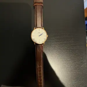 Klocka från Daniel Wellington i guld med läderarmband. 