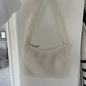 En supergullig fluffig vit väska i fakepäls, älskar den men tyvärr har den bara kommit till användning ett par gånger :( 