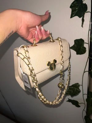 *NY* supersöt väska med flera fack/kawaii disney gulddetaljer - Väska köpt i en japansk/koreansk inspirerad affär på triangeln i Malmö! Nypris ca 260kr. Använd en gång 💕✨ beige/creme med tre olika fack inuti och flätad kedja med en guldbjällra på ❤️