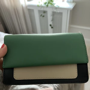 Clutch grön - En multi färgad Clutch i grönt/mörkgrönt och beige. Så fin att ha vid finare tillställningar.