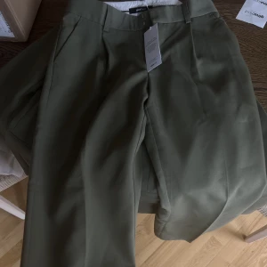 Kostymset - Helt nytt kostymset från Gina tricot. I en jättefin grön färg!  Fanns tyvärr inte i rätt storlek och jag kan inte längre lämna tillbaka det.  Byxorna kostar 499 i butik och kavajen 599. 800 för båda delarna!   Byxorna storlek M kavajen storlek S