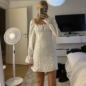 Klänning - Supersöt vit klänning med blommor på som tyvär inte kommit till användning, helt oanvänd med lappen kvar💕 storlek xs men passar mig som brukar ha s