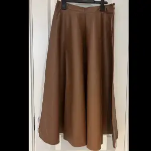 Lång kjol i skinn, färgen brun. Använd 1 gång, ser heelt ny ut. Den är i storlek 40. Priset kan diskuteras!
