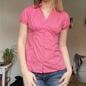 Kortärmad skjorta - Kortärmad skjorta i en stark rosa färg! Insydd i ryggen men det går att sprätta upp. Skriv för fler bilder!
