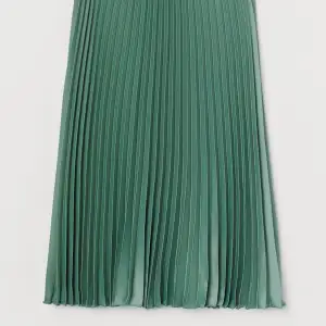 Grön plisserad kjol i sidenmaterial