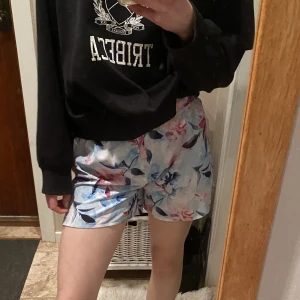 Blåa shorts  - Blåa träningsshorts med blommor på och har ett rosa midjeband på insidan från Soc💕Använda ca 5 gånger och har inga fel. Strl. 158/164 men passar också XS.