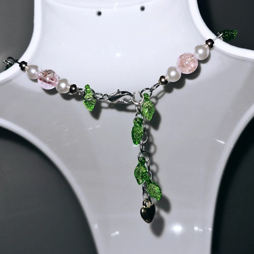 Ett vackert halsband som består av vita och rosa akrylpärlor, roséguld pärlor, gröna blad och guldigt hjärta. . Accessoarer.