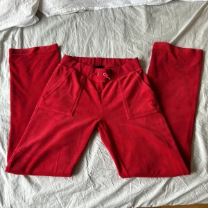 röda juicy - röda juicy couture byxor, använd några gånger, har tappat varm olja och det har skvättar på byxorna, (se bild 3) d silvriga grejerna på smörerna är borta, byxorna är lite noppriga (se bild 4) annars bra skick
