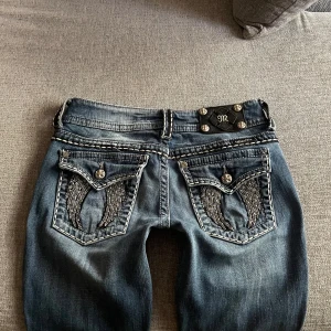Miss Me jeans - Ett par blå jeans från Miss Me med dekorativa detaljer på bakfickorna och framsidan. Jeansen är Lågmidjade och boootcut. Midjemått 37 Innerbenslängd 76. Har lite slitage längst ner 💗 Jag är 165