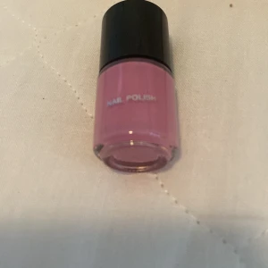 Rosa nagellack - Ett rosa nagellack i en liten flaska med svart lock. Perfekt för att ge dina naglar en fin och färgglad look.