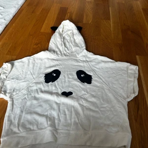 Panda hoodie till barn - Söt, skön panda hoodie med korta armar. Lite oversized. Passar 12-13 åringar beroende på hur man är i storlek. Skulle säga annars xs. Köpte från England. 