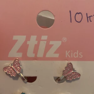 Rosa fjärilsörhängen från Ztiz Kids - Ett par söta örhängen i form av fjärilar från Ztiz Kids. Örhängena är rosa med silverdetaljer.