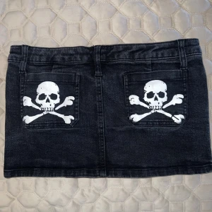 Tripp New York Mini Skirt - Vintage mini kjol med dödskalle på fickorna.  Står att det är storlek L men passar mig fint som har storlek 34,36. Ny pris: 800kr  Fråga gärna för bilder