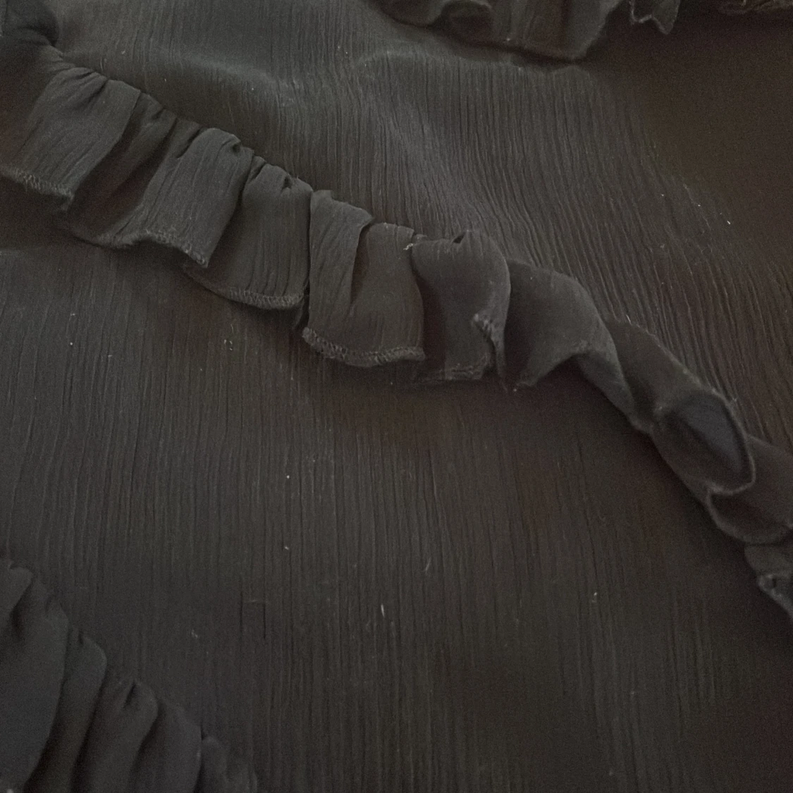 Svart klänning med volanger  - 90