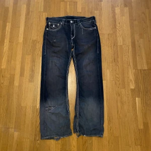 True religion jeans - Feta jävla svarta trueys med wash. Bootcut fit. Lite heelbite defekter men de är bara snyggt. Pris går att diskuteras mått: Ytterben: 110cm Ish midja: 47cm Benöppning: 26cm
