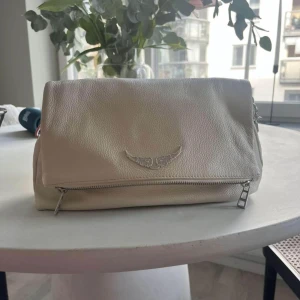 Zadig Voltaire väska - Zadig Voltaire ”Rocky bag” (alltså lite större)  Kommer även med ett axelband i ormmotiv. Nypris: 5000 kr 